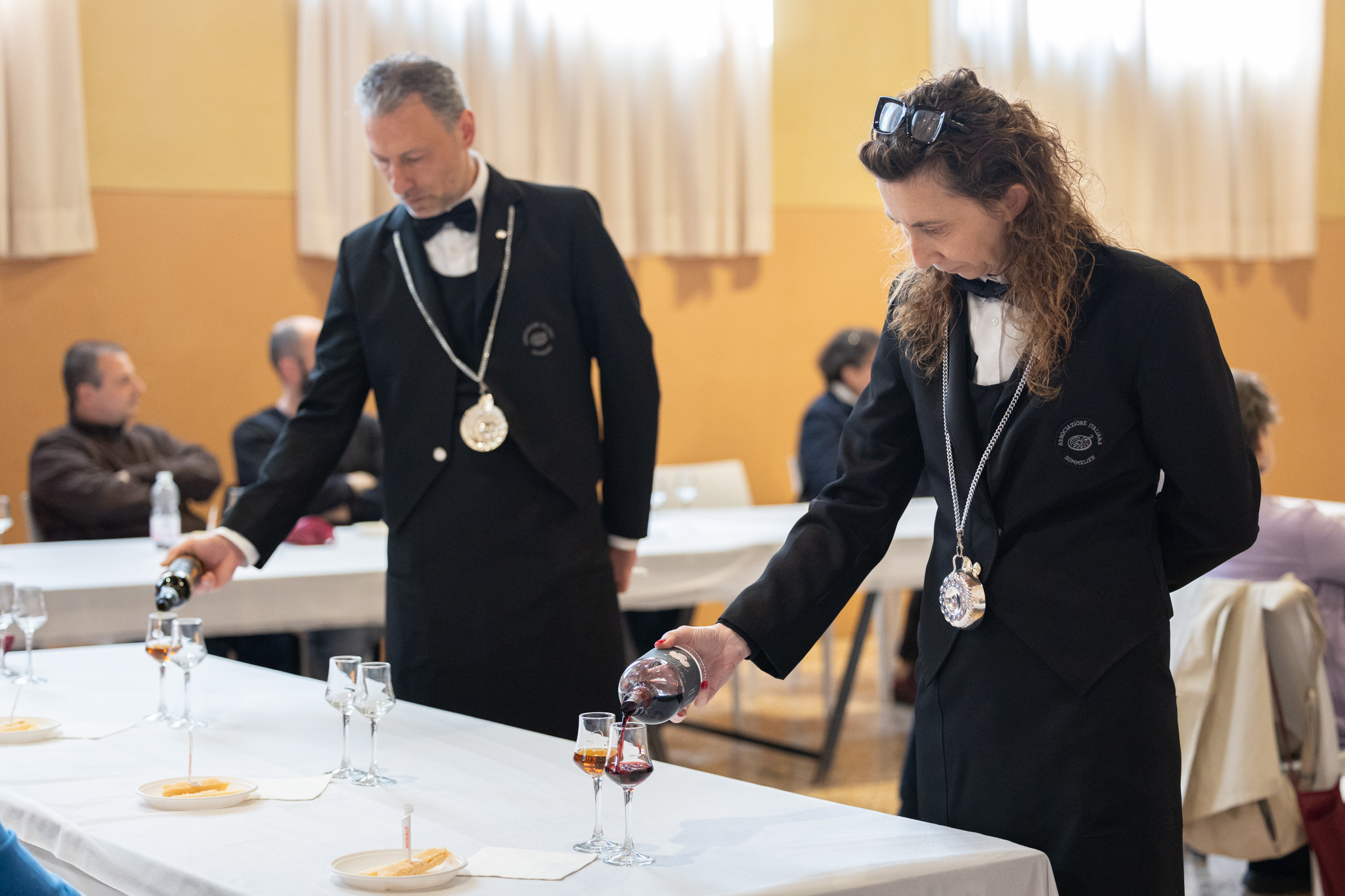 Sommelier AIS che servono il vino alla mostra passiti
